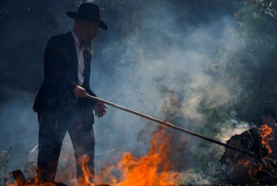 An ultra-Orthodox Jewish man burns leavened items in preparation for Passover, Bnei Brak, Israel, Apr. 5, 2023. (AP Photo)